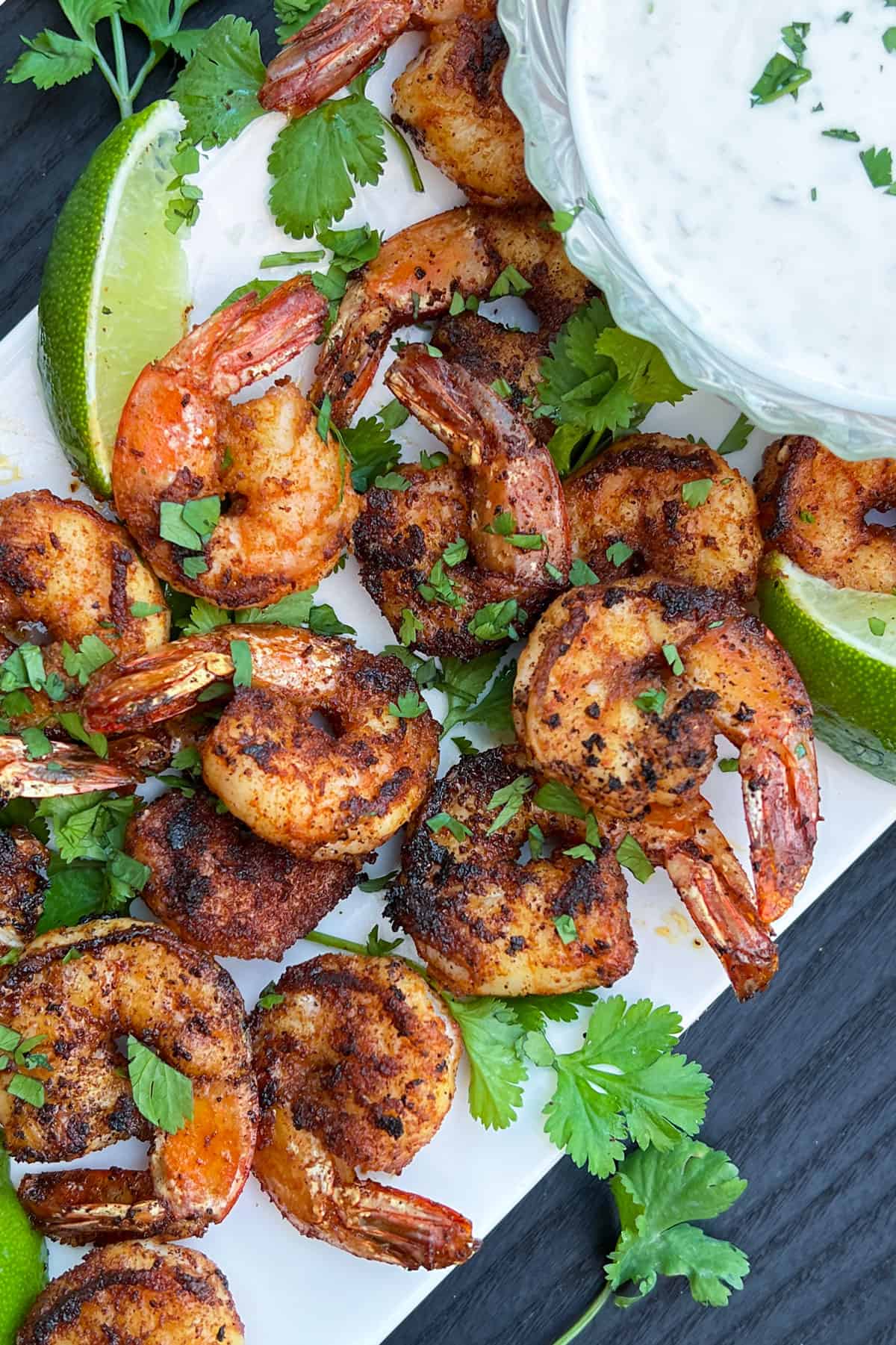 sauteed shrimp on a white platter with wedges of lime