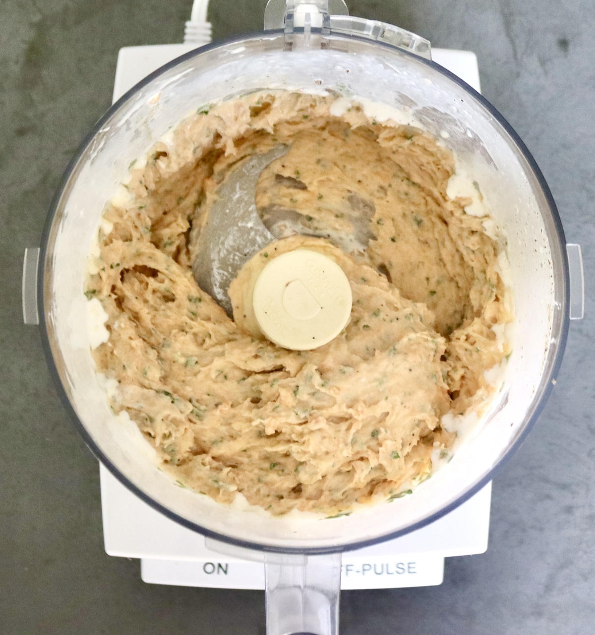 Salmon mousse in a food processor bowl fitted with the blade attachment.