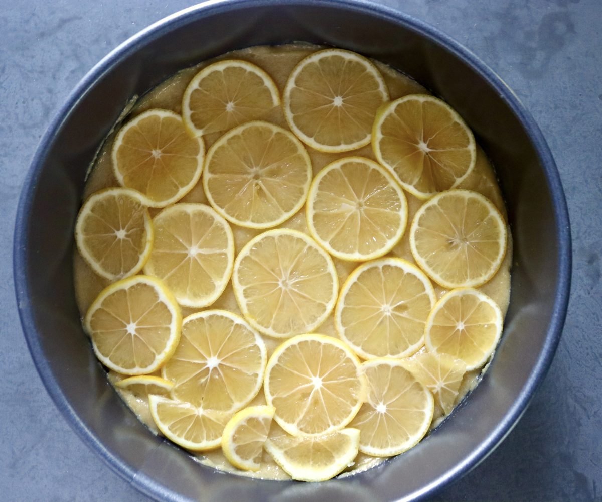 Slice the lemon over the batter in the cake pan.
