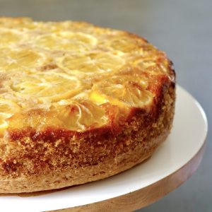 All Lemon Oil Cake on a white wood cake stand.