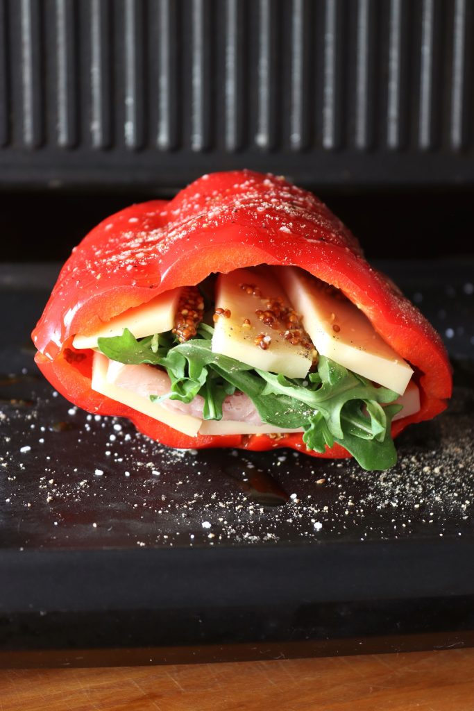 Red bell pepper stuffed with cheese lettuce and ham on the grill