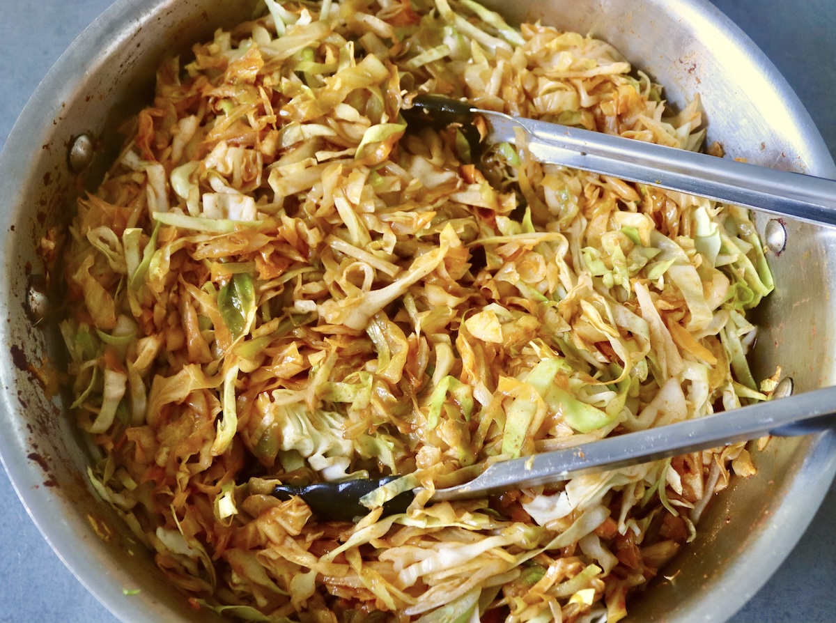 Boiled and wilted cabbage with tomato sauce in a pan with a baking sheet.