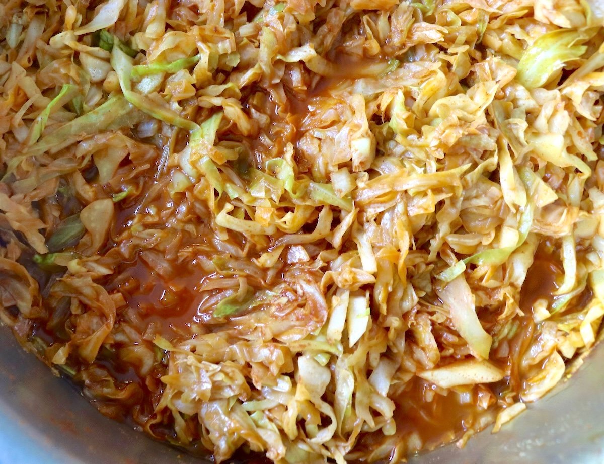 Cabbage is boiled and dried with tomato sauce in a hot pan.