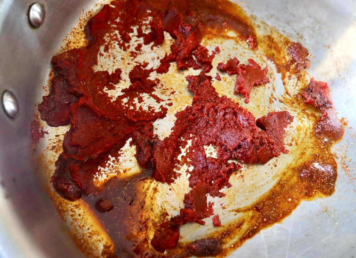 Tomato paste and spices in the bottom of the pan.