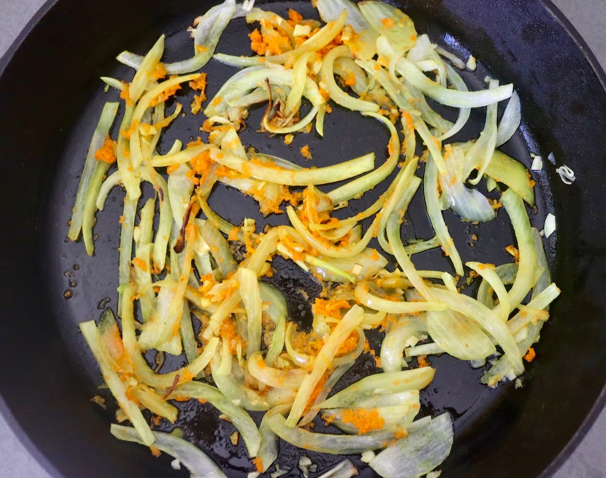 Hombe cast iron skillet ine sautéed onion uye nyowani grated turmeric.