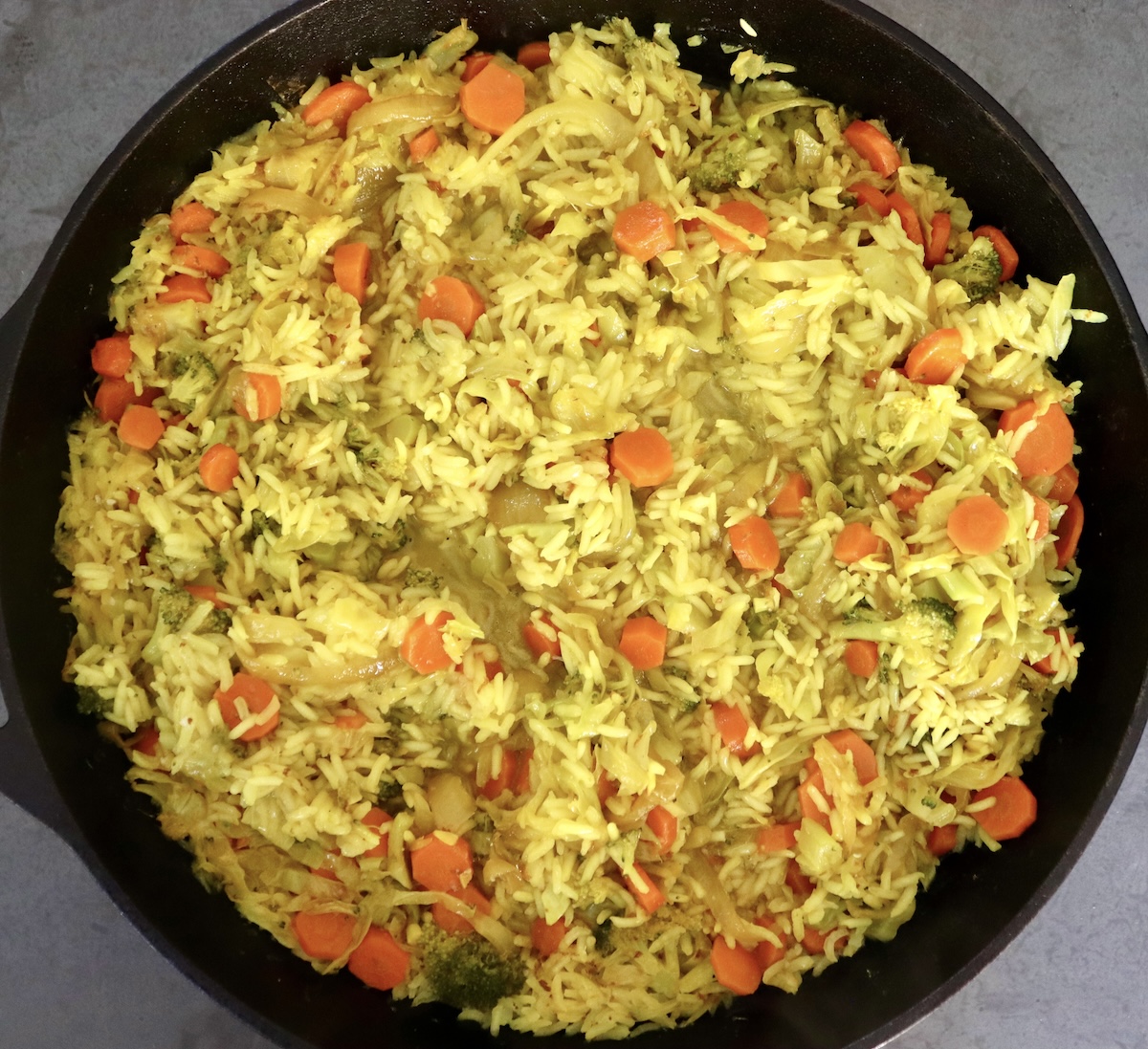 Large cast iron skillet yakazadzwa nekabichi, broccoli, hanyanisi, makarotsi, mupunga zvishoma mvura.