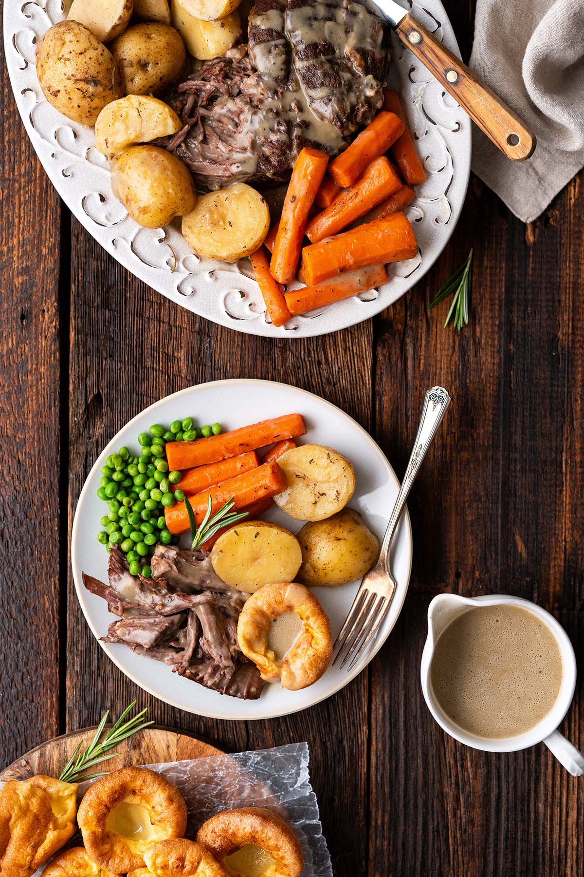 pot roast meal with Yorkshire pudding and gravy on rustic dark wooden pub table