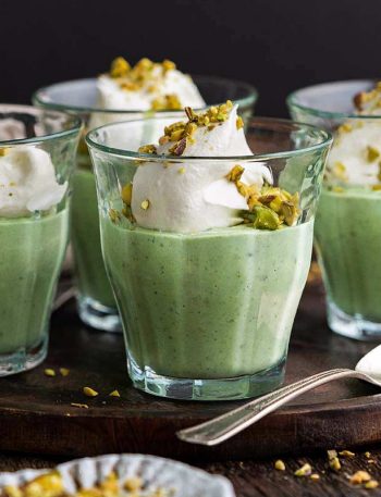homemade pistachio pudding dessert in serving glasses on rustic wooden table