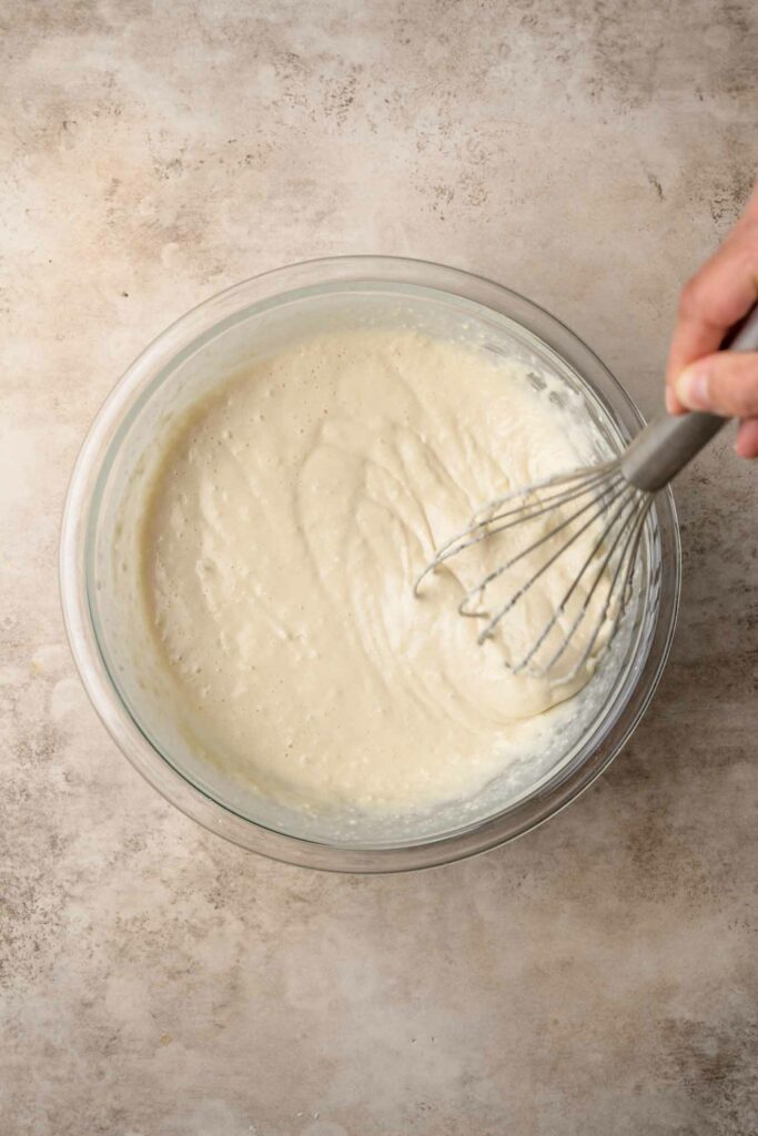 vegan Belgian waffle batter mixed together with a whisk showing the smoothness of the batter