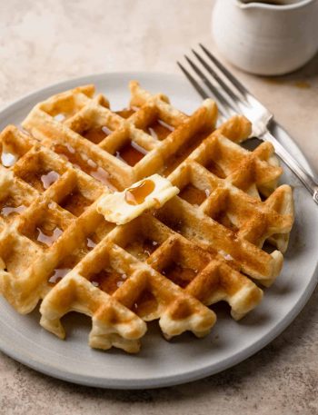 vegan Belgian waffle topped with maple syrup and vegan butter