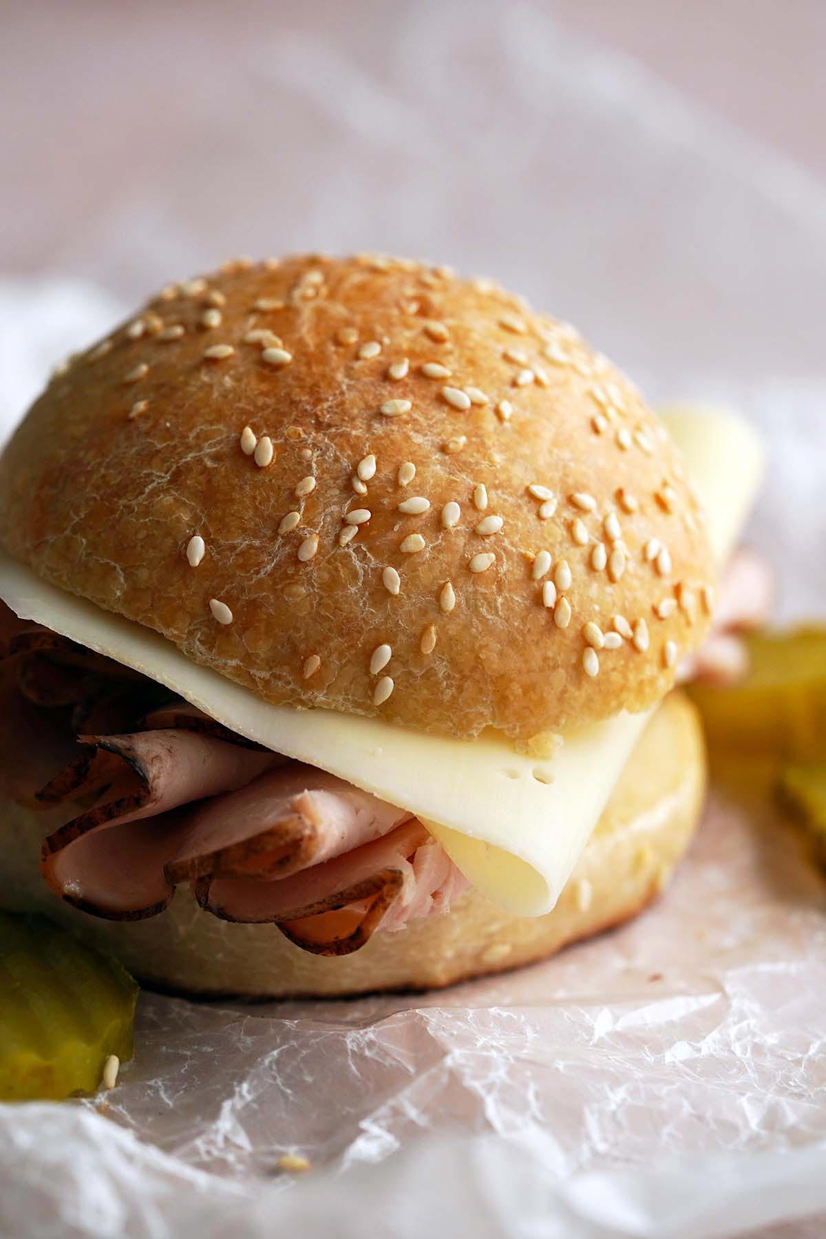 front view of turkey and Swiss sandwich on sesame sourdough roll