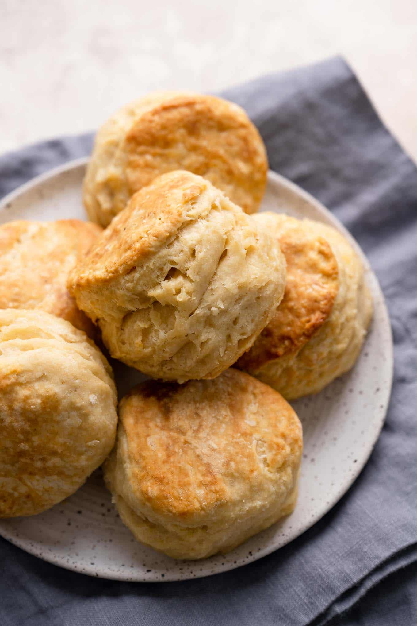 flaky vegan biscuits on a plate resting on a linen cloth