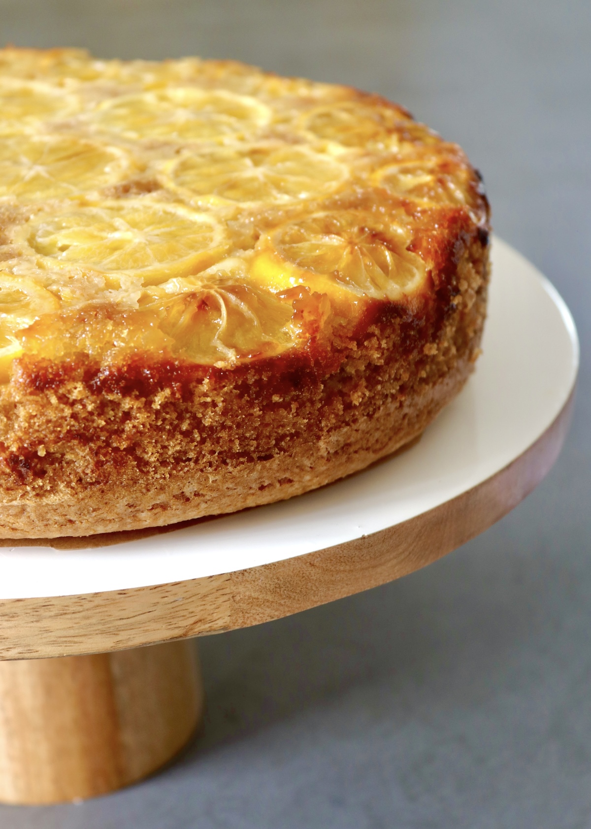 All Lemon Oil Cake on a white wood cake stand.